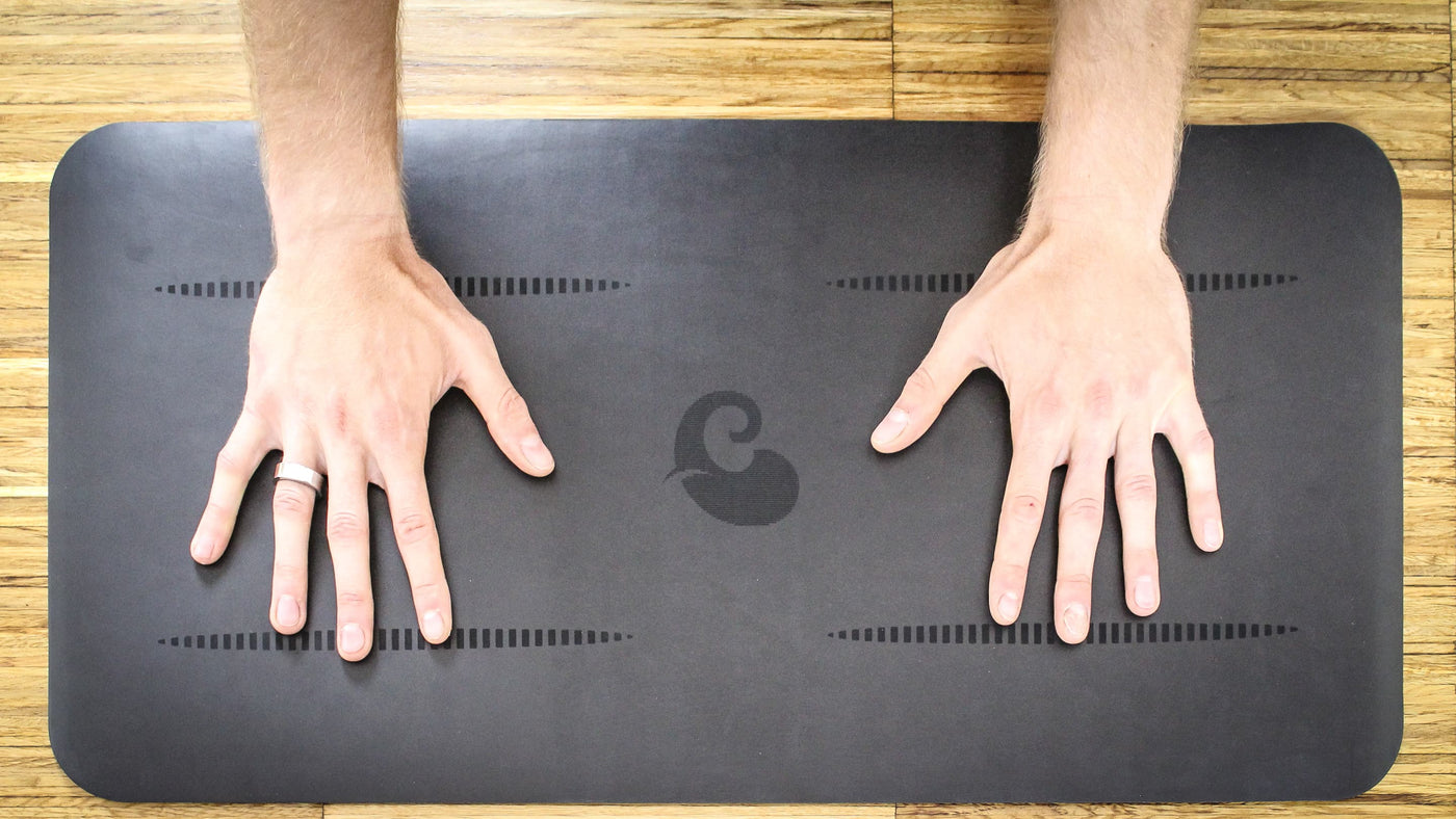 Hände auf schwarzer rutschfester Yogamatte